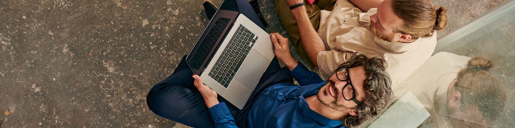 Internet Aktion: Mann mit Laptop lächelt in Kamera