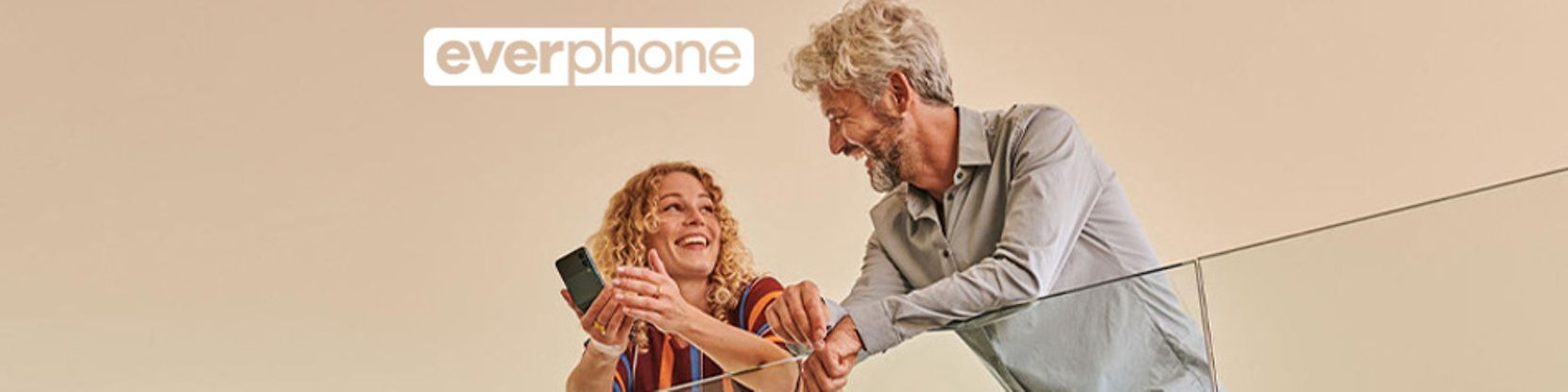 Mann und Frau lehnen an Geländer mit Smartphone