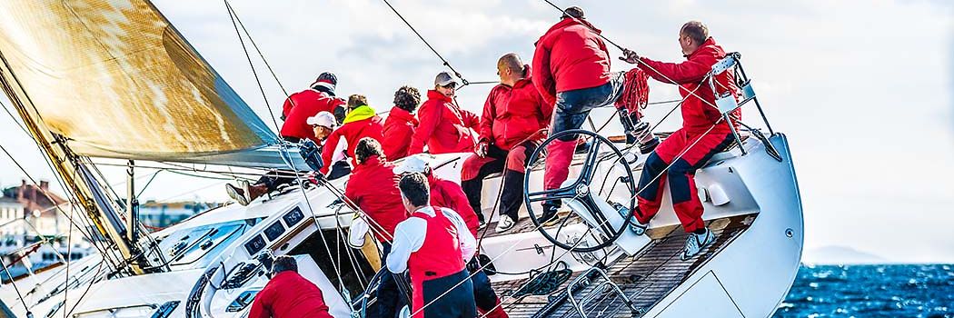 Menschen mit roten Jacken auf einem Segelboot