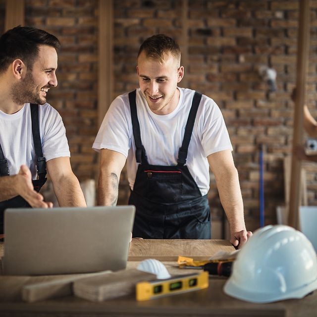 Handwerker planen am Laptop und nutzen Glasfaser