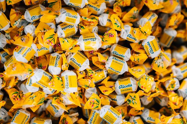 Ganz viele Ricola Bonbons in gelbes Papier eingewickelt.