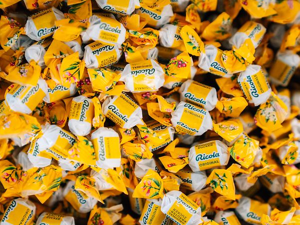 Ganz viele Ricola Bonbons in gelbes Papier eingewickelt.