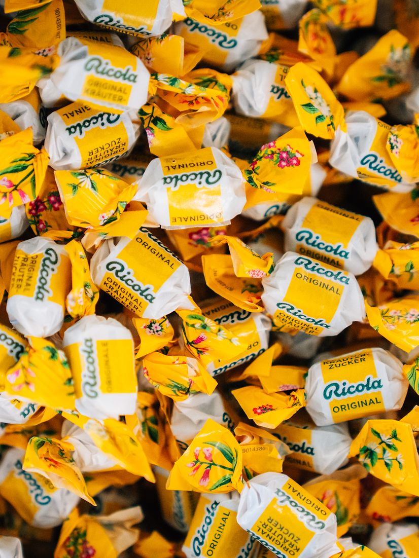 Ganz viele Ricola Bonbons in gelbes Papier eingewickelt.