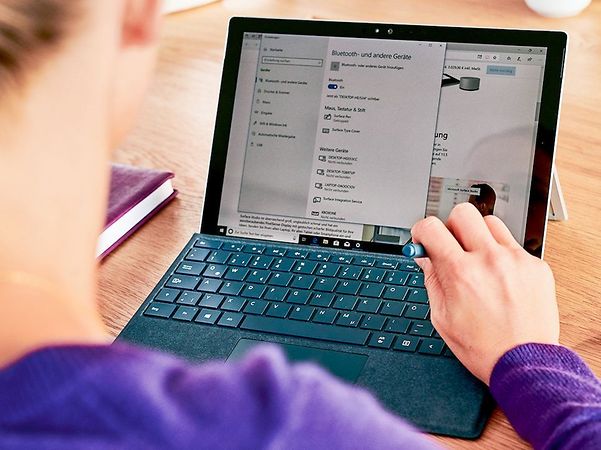 Im Vordergrund ist eine Frau mit Laptop, oben links der Schriftzug ‚Security Cave‘.“