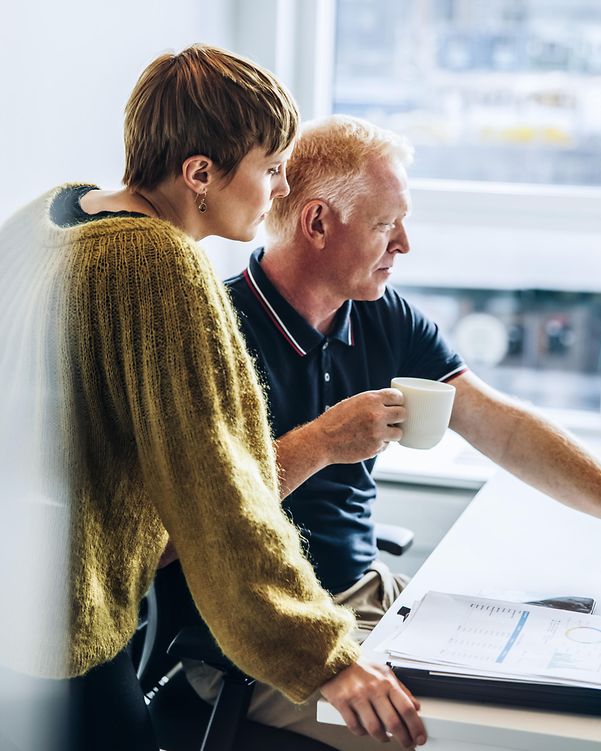 Man and woman discussing something at the computer in the office
