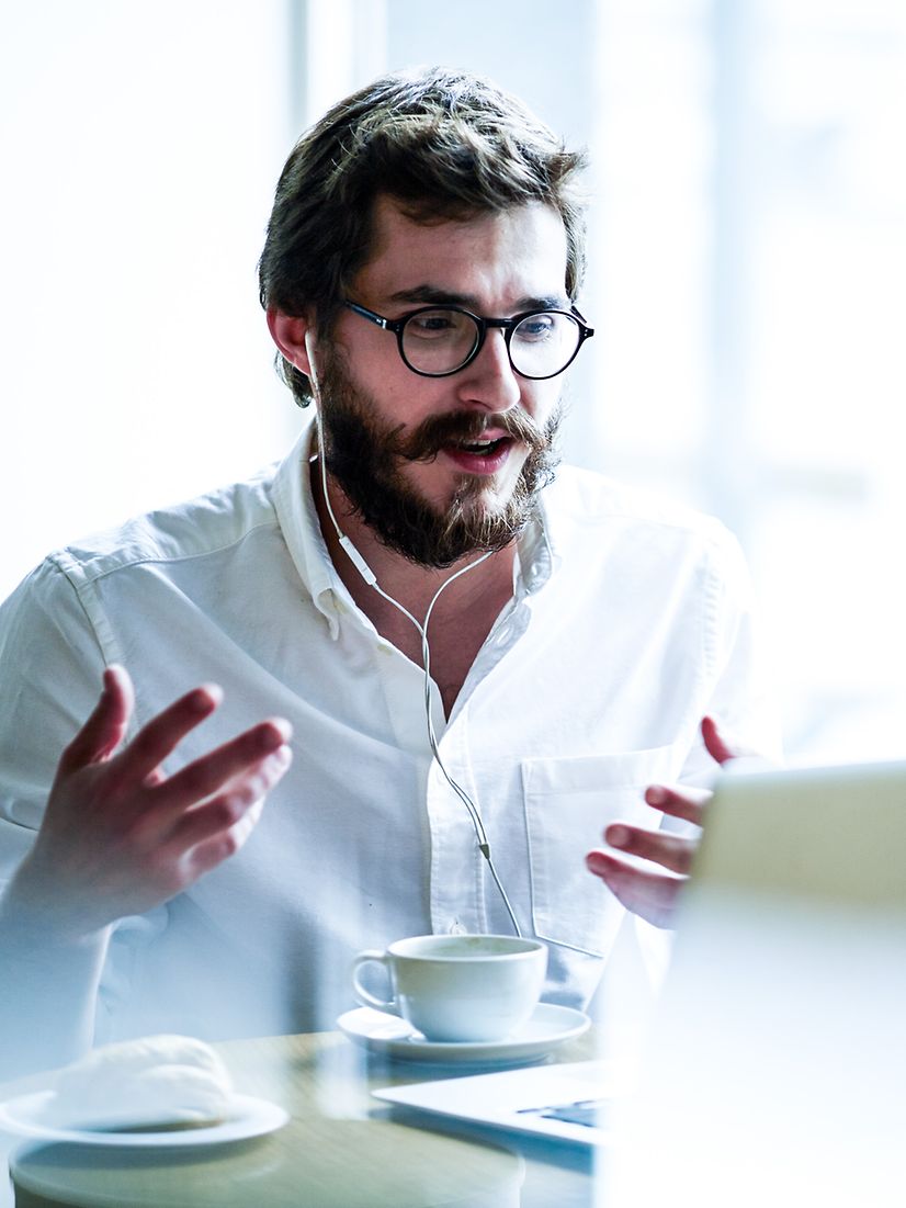 Man sitting enthusiastically in front of his laptop