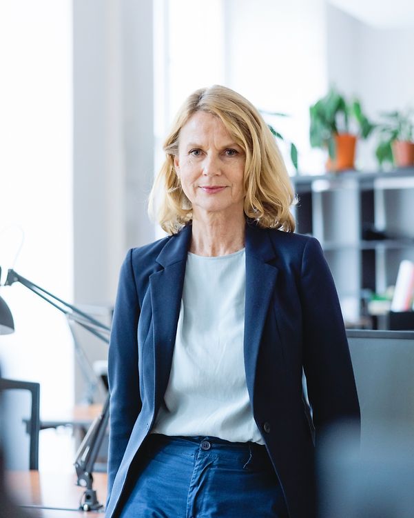 Portrait of a confident, mature businesswoman standing at a desk in an office