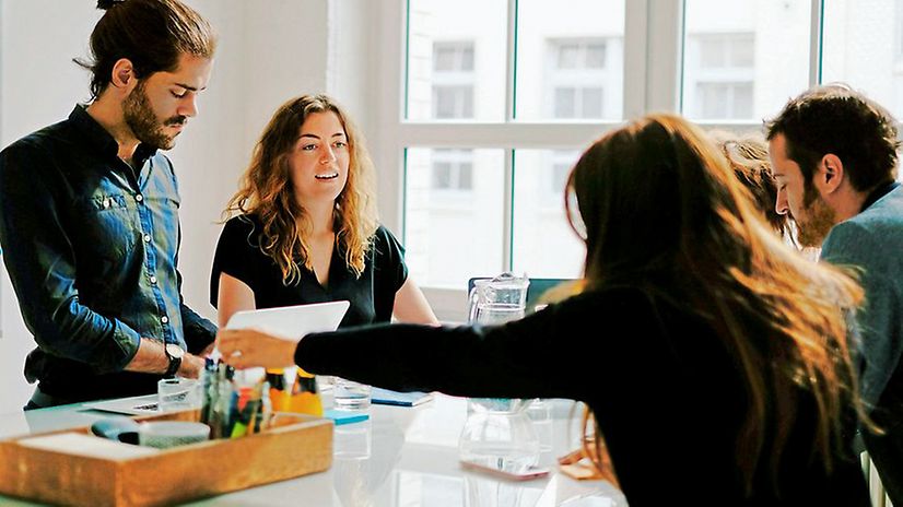 Several colleagues at a conference table discuss T Business's Cloud Solution Partner Programme.