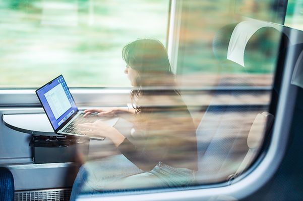 A young woman works on the train.