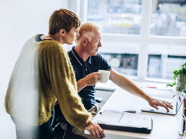 Man and woman discussing something at the computer in the office