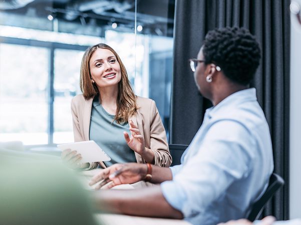A young businesswoman advises a customer on Copilot Studio.