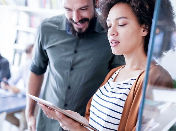 Two people looking at a tablet together