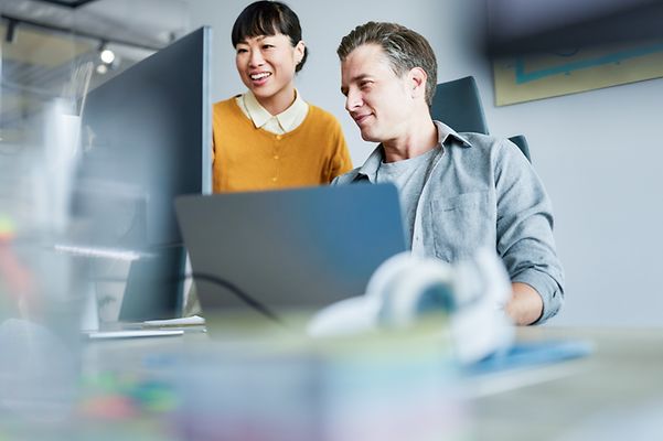 Colleagues look at a screen together