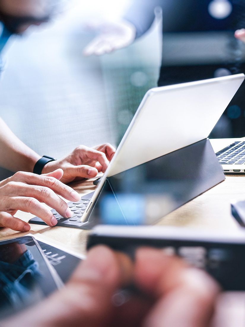 Start-up programming team. Website designer working at a digital table using Microsoft Copilot.
