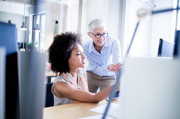 Colleagues look together at a monitor on which Zoom Whiteboard is open.