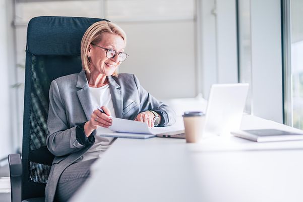 Older businesswoman working on her laptop in a modern office