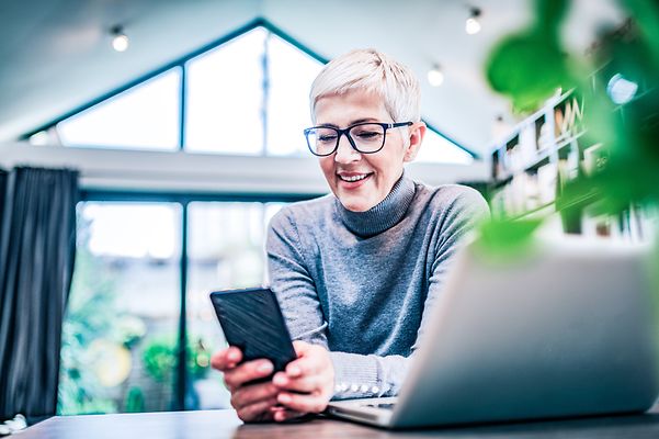 A woman looks at her smartphone in the office.