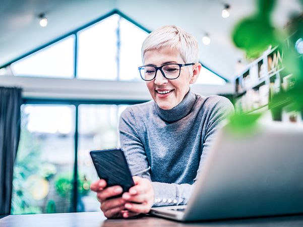A woman looks at her smartphone in the office.