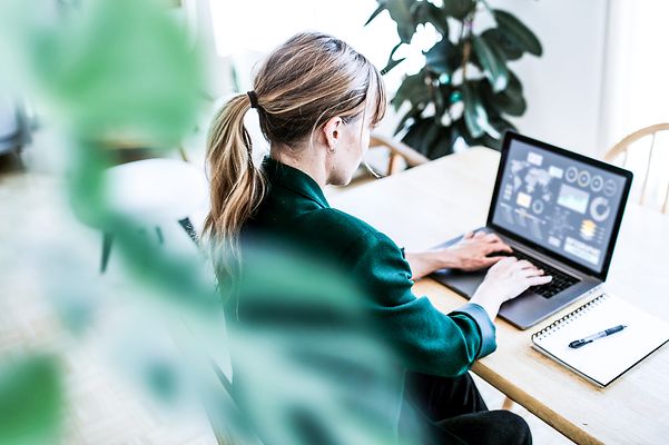 A businesswoman looks at analysis data on her notebook.