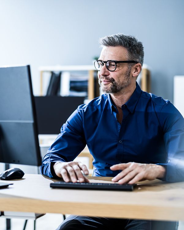 Man with glasses signing a document on his laptop with DocuSign