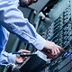 Hands of a man in a business shirt operating a server cabinet
