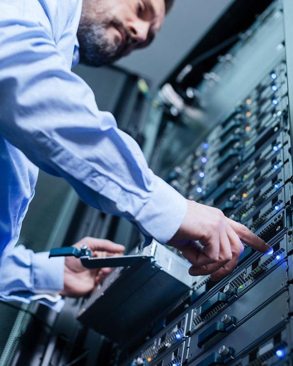Hands of a man in a business shirt operating a server cabinet