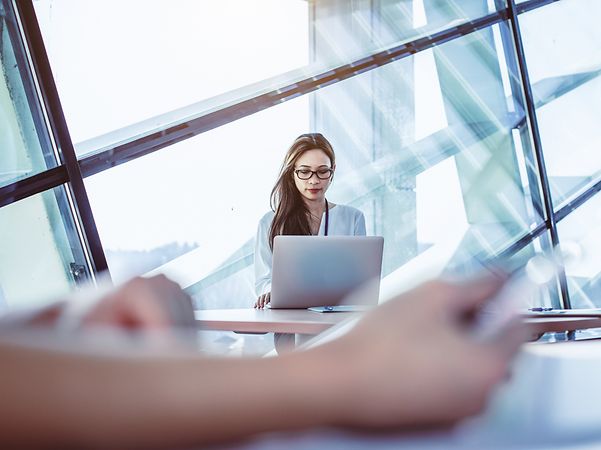 Junge Frau sitzt vor ihrem Laptop und nutzt ConnectWise Cloud Backup für ihre Microsoft 365 Daten.