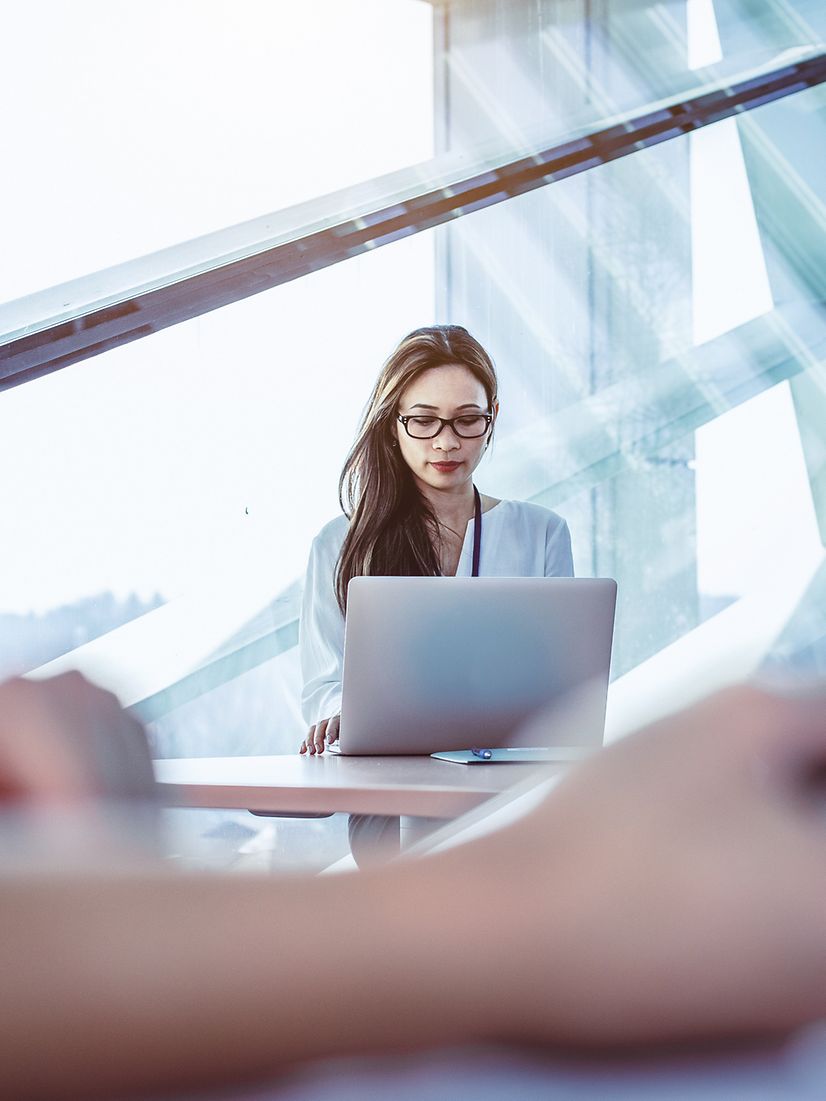 Junge Frau sitzt vor ihrem Laptop und nutzt ConnectWise Cloud Backup für ihre Microsoft 365 Daten.