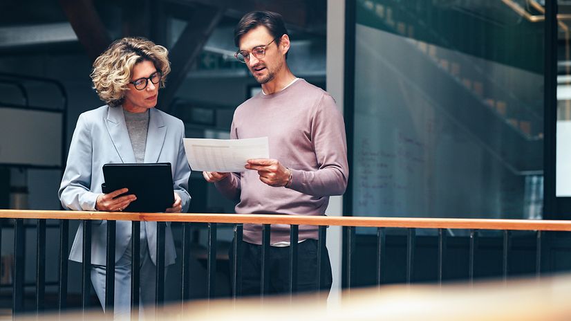 Business people read a document together and learn about Salesforce from Telekom.