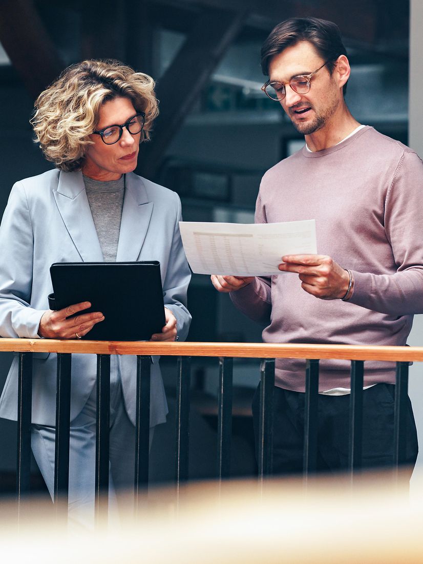 Business people read a document together and learn about Salesforce from Telekom.