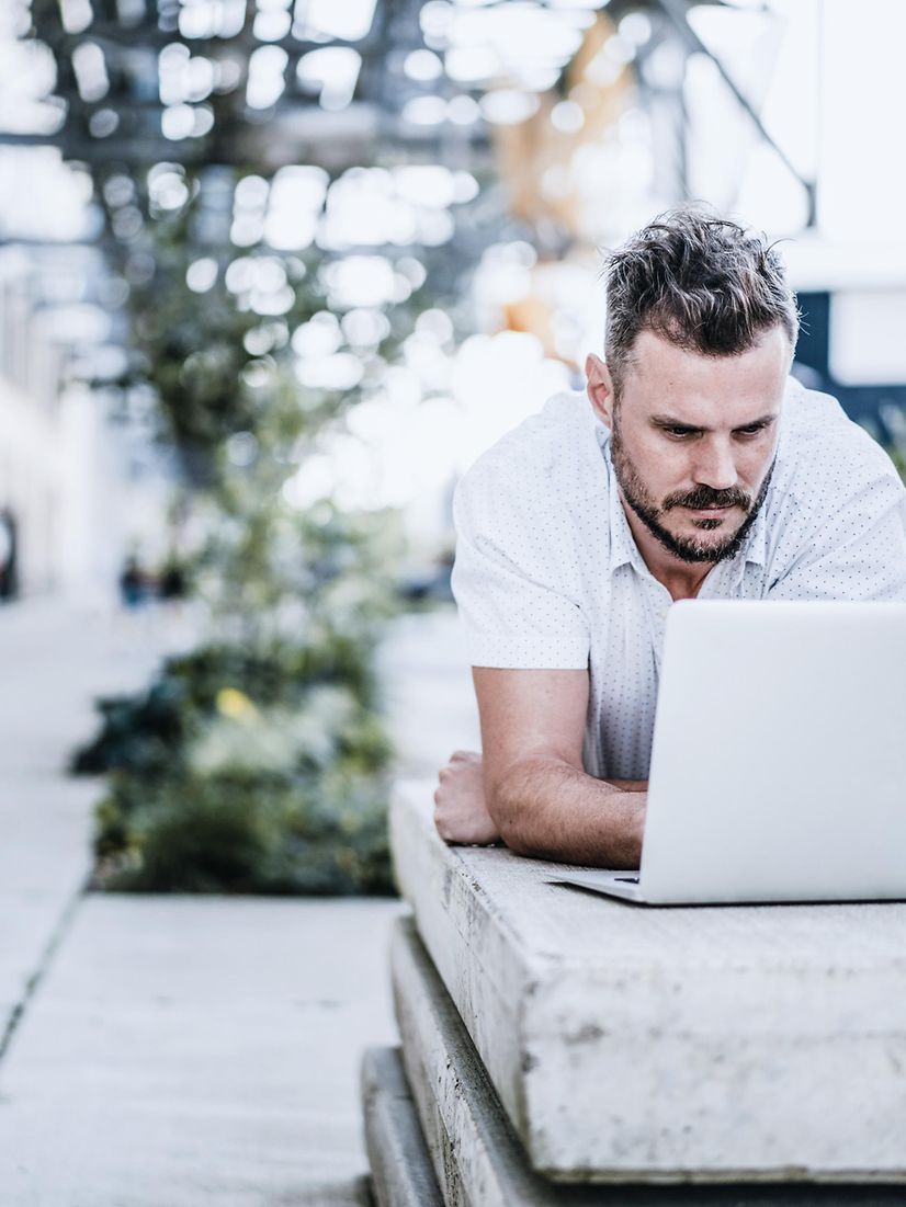 A man at his laptop reads the Salesforce Health Check flyer.