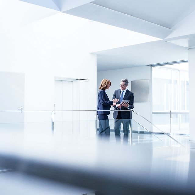 Business people with digital tablets in the office corridor