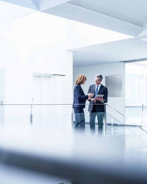 Business people with digital tablets in the office corridor