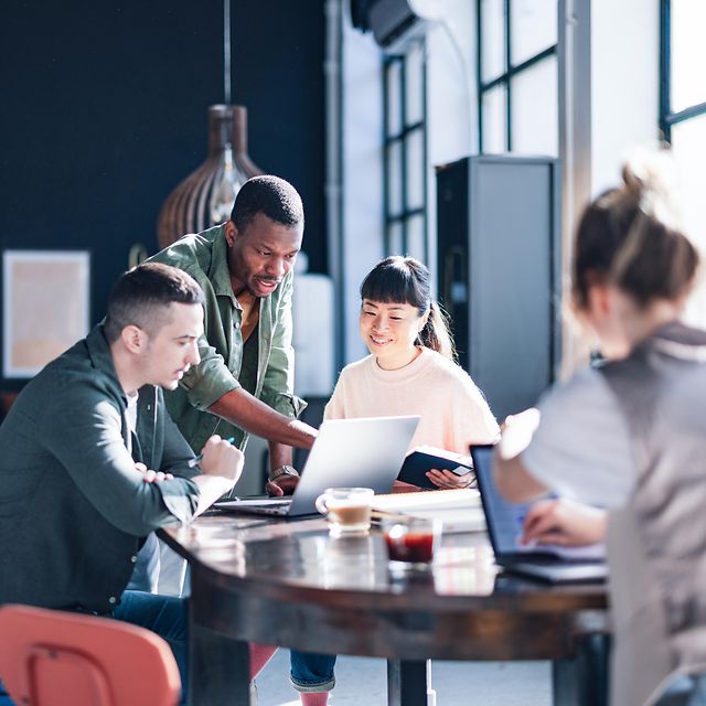 Vielfältiges Team, das in einem modernen Co-Working-Space zusammenarbeitet
