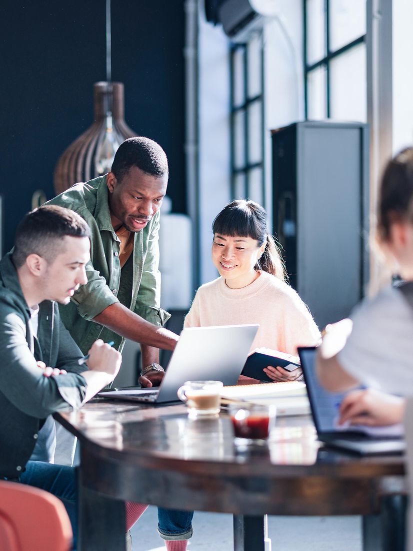 Vielfältiges Team, das in einem modernen Co-Working-Space zusammenarbeitet