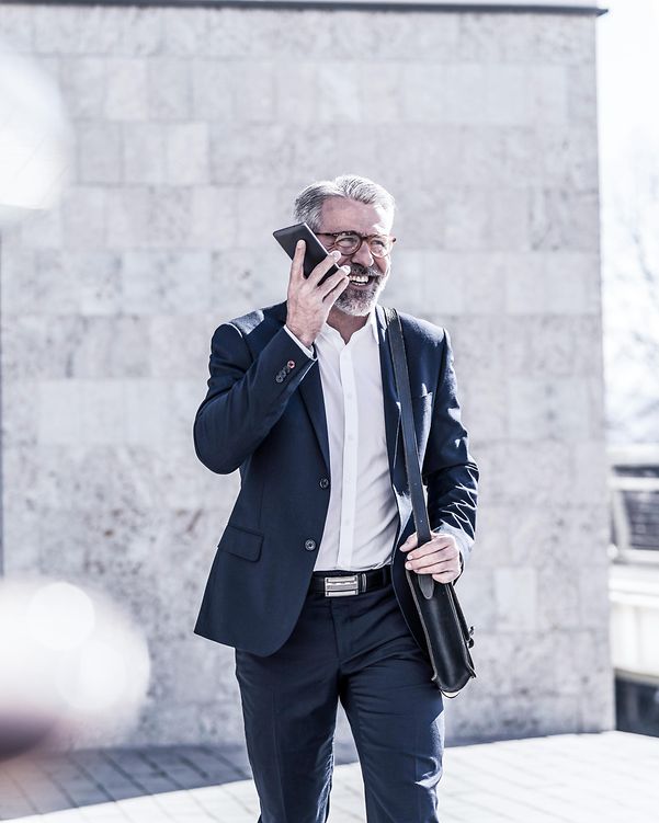 A businessman is having a conversation on his mobile phone about Microsoft Azure.