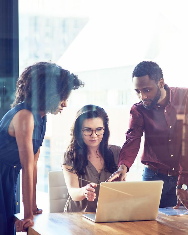 Colleagues discussing Managed Platform as a Service in front of an open laptop
