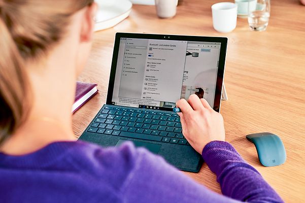 A woman works on her laptop and finds out about Open Telekom Cloud.