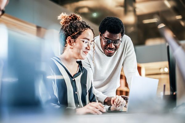 A woman and a man are looking at the screen.