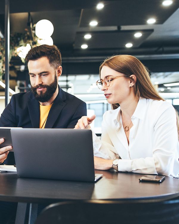 A woman and a man at a bar table compare the availability of cloud providers.