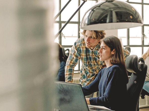 Woman and man discussing staking in an office environment