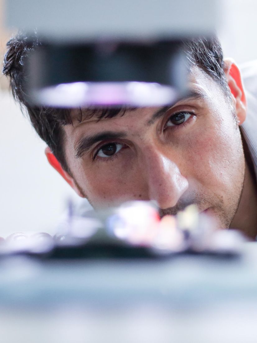 A person in light-coloured clothing leans forward to inspect a backup system.