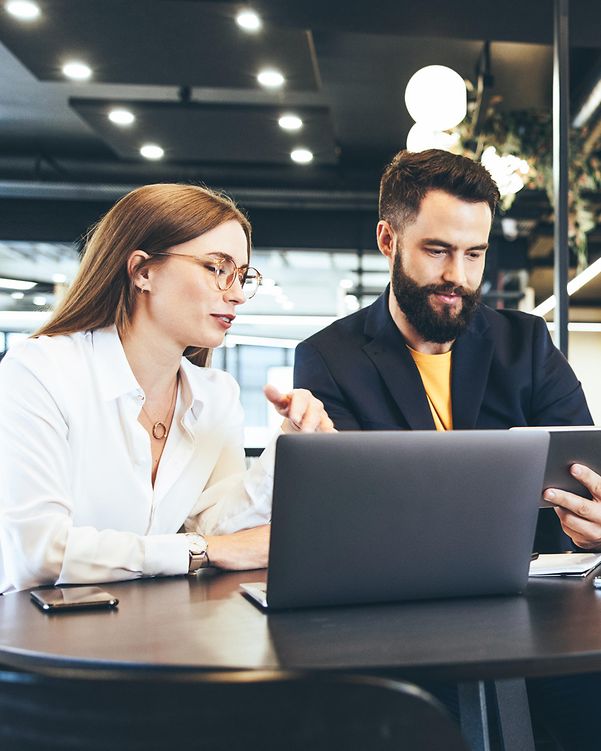 Two people working remotely in a public place with Managed Workplace