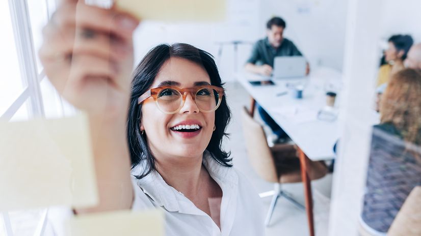 Woman in a meeting explains the various tailor-made IT infrastructure solutions for business customers to her colleagues.