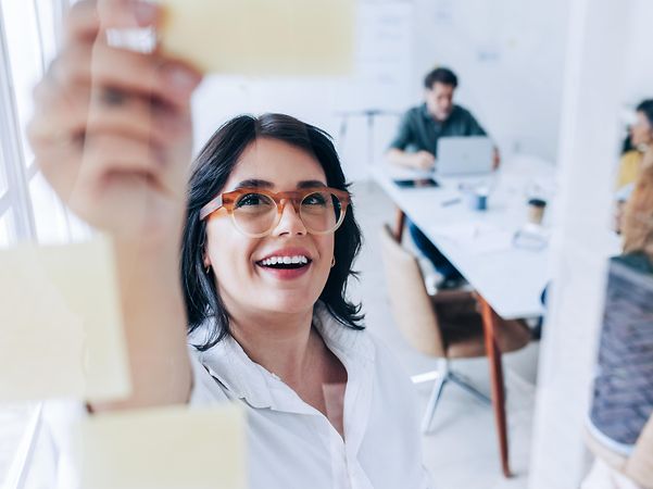 Woman in a meeting explains the various tailor-made IT infrastructure solutions for business customers to her colleagues.