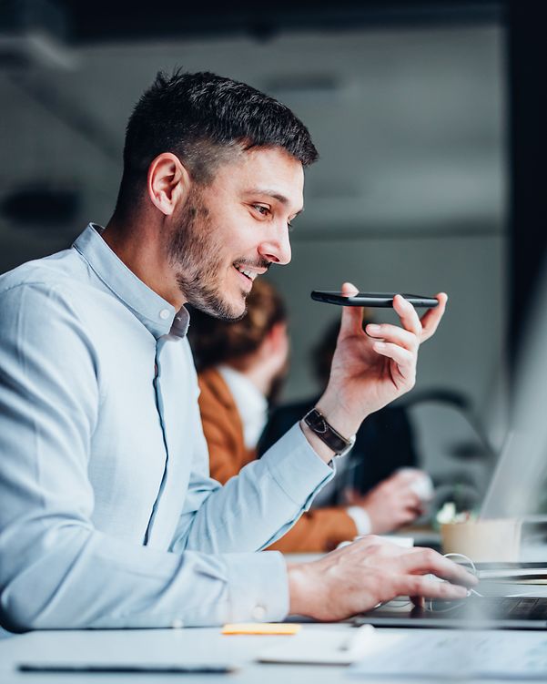 Happy businessman talking on a mobile phone in a modern office