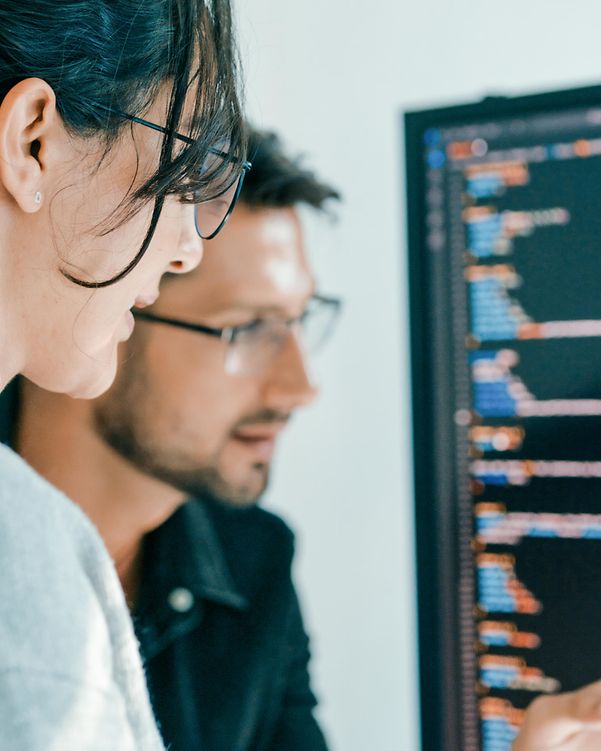A software development team in front of two screens is busy analysing an attack.
