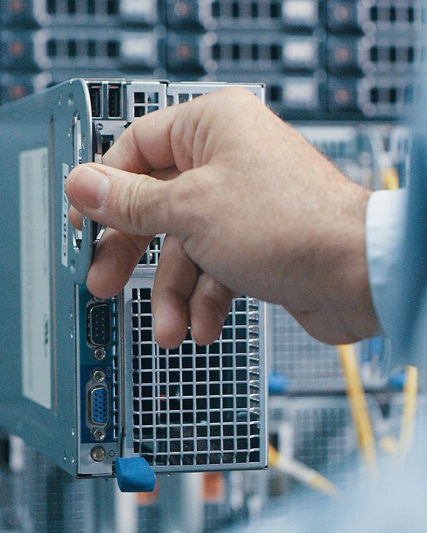 Recording of a man inspecting a hard drive in a data centre