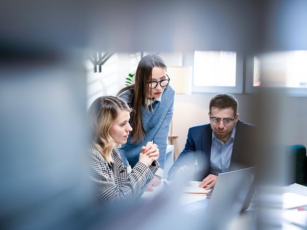 Colleagues discussing public key infrastructure at their desks in the office