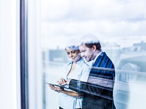 A man and a woman learn about secure mobile solutions on a tablet.